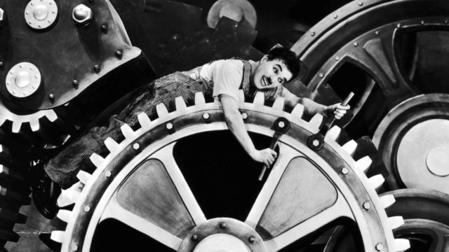 تشارلي شابلن من فيلم الأزمنة الحديثة (1936) الذي جسد فيه عبودية الإنسان للعمل واستغلاله