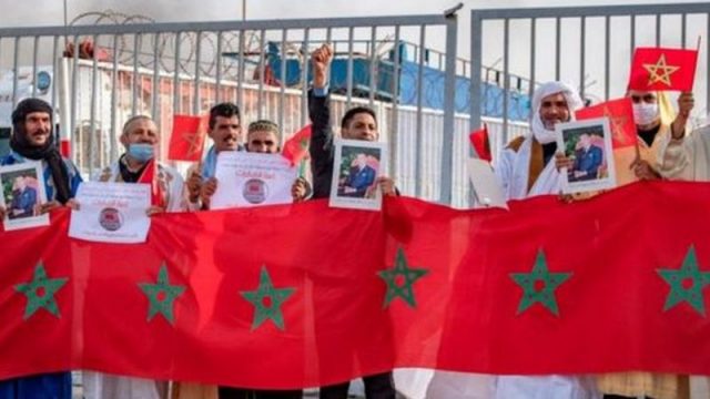 اشخاص يحملون أعلاما مغربية