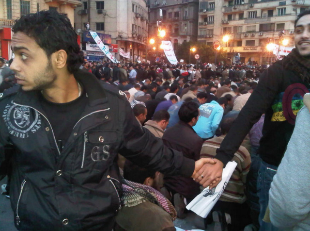 مسيحيون يحيطون المتظاهرين المسلمين أثناء الصلاة في ثورة 25 يناير