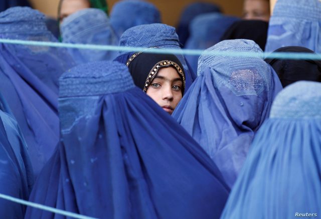 فتاة تنظر بين الأفغانيات اللواتي يصطفن لتلقي مساعدات الإغاثة