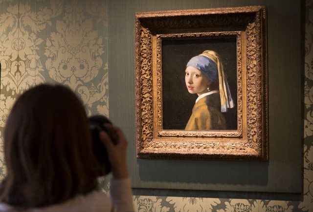 عرض لوحة "الفتاة ذات القرط اللؤلؤي" ليوهانس فيرمير في متحف موريتشيس في لاهاي بهولندا