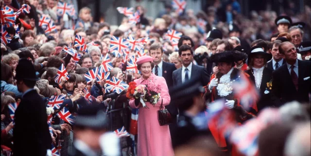 إليزابيث وفيليب يتنقلان بين حشد يلوح بالأعلام في جولة في لندن في 31 أكتوبر 1984. 